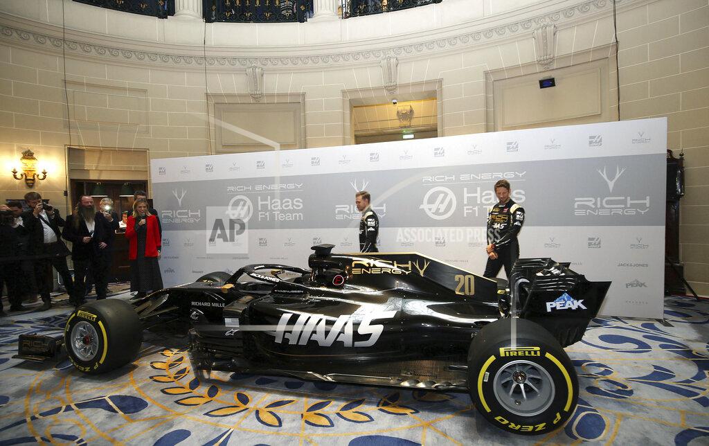Steven Paston Drivers Romain Grosjean, right, and Kevin Magnussen pose during the unveiling of their new Rich Energy Haas F1 Team 2019 car, launched at the Royal Automobile Club in London, Thursday Feb. 7, 2019. (Steven Paston/PA via AP)