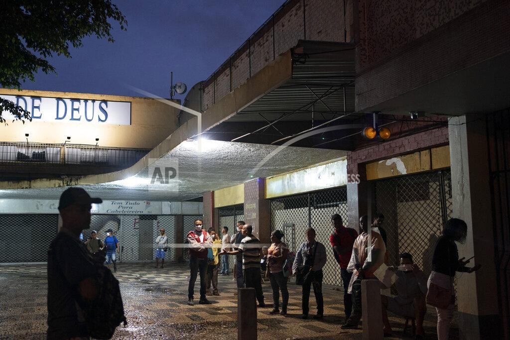 Leo Correa People wait outside a federal revenue office in Rio de Janeiro, Brazil, early Friday, April 17, 2020. People begin lining up before dawn outside the office which doesn't open until 9 am, in hopes of fixing their taxpayer registration number which will allow them to receive emergency aid allotted by the federal government for the most vulnerable persons amid the new coronavirus pandemic. (AP Photo/Leo Correa)