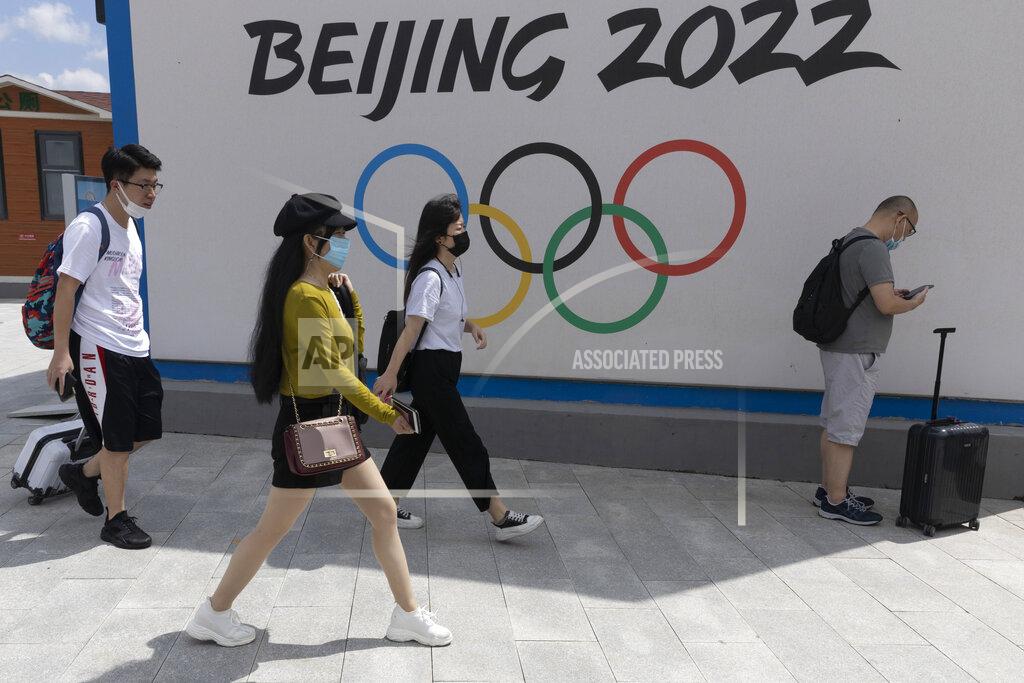 Ng Han Guan Visitors to Chongli, one of the venues for the Beijing 2022 Winter Olympics, pass by the Olympics logo in Chongli in northern China's Hebei Province on Aug. 13, 2020. The coronavirus’s delta variant is challenging China’s costly strategy of isolating cities, prompting warnings that Chinese leaders who were confident they could keep the virus out of the country need a less disruptive approach. China’s controls will be tested when thousands of athletes, reporters and others arrive for the Winter Olympics in Beijing in February. (AP Photo/Ng Han Guan)