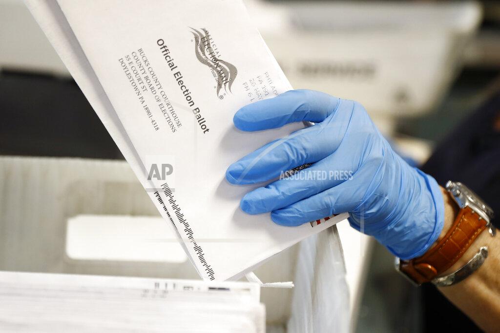 FILE - In this May 27, 2020 file photo, a worker processes mail-in ballots at the Bucks County Board of Elections office prior to the primary election in Doylestown, Pa. A network of deep-pocketed progressive donors are launching a $59 million effort to encourage people of color to vote by mail in November, a step many Democrats view as crucial to turning out the party's base during a global pandemic. (AP Photo/Matt Slocum, File)