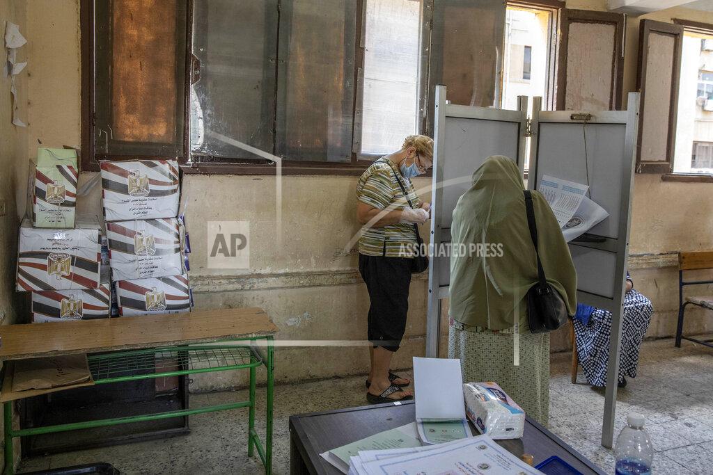 Nariman El-Mofty Women vote on the first day of the Senate elections inside a polling station in Cairo, Egypt, Tuesday, Aug. 11, 2020. Egyptians started voting on Tuesday for the Senate, the upper chamber of parliament that was revived as part of constitutional amendments approved in a referendum last year — an election that comes as the country faces an uptick in daily numbers of new coronavirus cases. (AP Photo/Nariman El-Mofty)