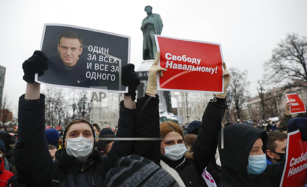 Pavel Golovkin People gather during a protest against the jailing of opposition leader Alexei Navalny in Pushkin square at the statue of Alexander Pushkin in the background in Moscow, Russia, Saturday, Jan. 23, 2021. Protesters hold posters reading "Freedom for Navalny!" and "One for all and all for one" with Navalny's portrait. Authorities in Russia have taken measures to curb protests planned for Saturday against the jailing of Navalny. (AP Photo/Pavel Golovkin)