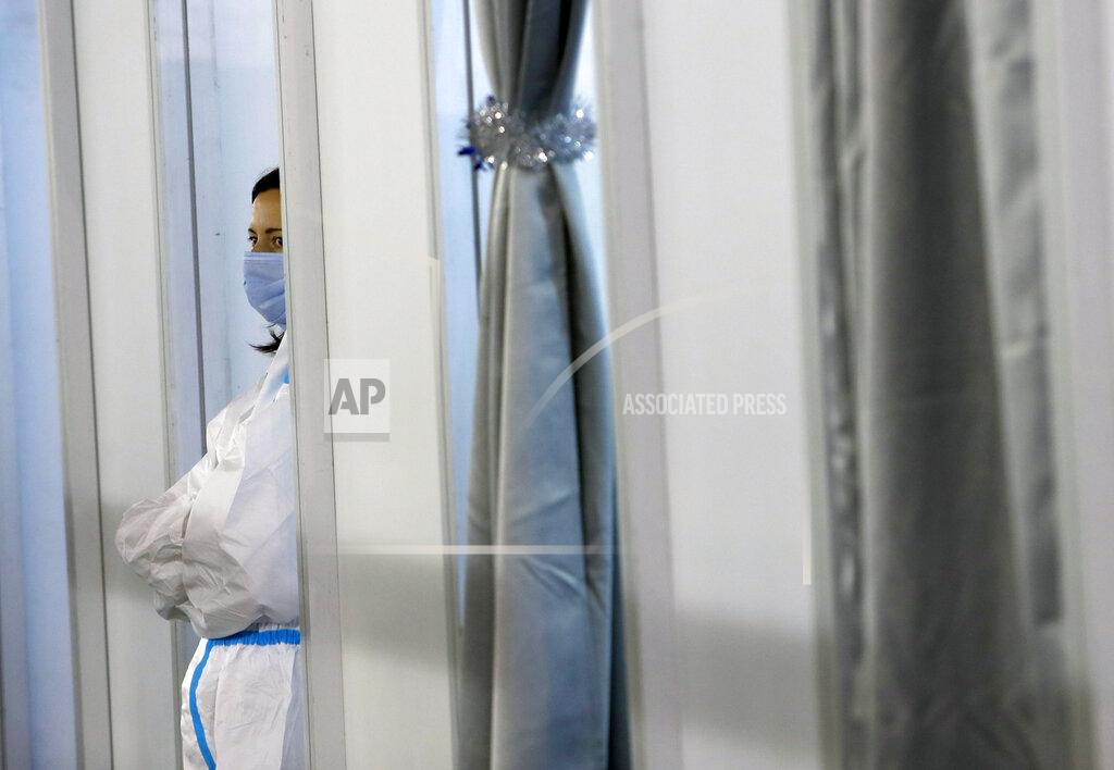 Darko Vojinovic A medical worker wearing protective gear waits for people to receive the COVID-19 vaccine, at Belgrade Fair makeshift vaccination center in Belgrade, Serbia, Tuesday, Feb. 9, 2021. China is ready to consider "vaccine cooperation" with Central and Eastern European countries, President Xi Jinping said Tuesday in a meeting held by video link with European leaders. Serbia has received 1 million doses of a Chinese-developed coronavirus vaccine and Hungarian and Chinese vaccine developers are cooperating. (AP Photo/Darko Vojinovic)