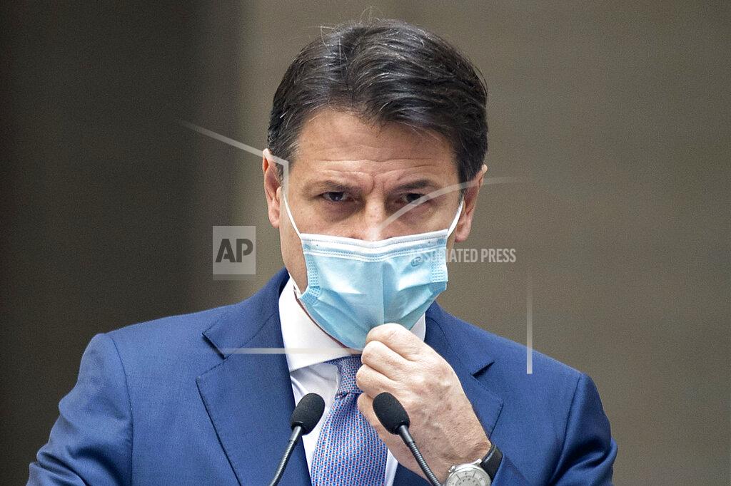 Roberto Monaldo Italian Premier Giuseppe Conte adjusts his face mask as he announces new rules to curb the spread of COVID-19, in Rome, Sunday, Oct. 25, 2020. For at least the next month, people outdoors except for small children must now wear masks in all of Italy, gyms, cinemas and movie theaters will be closed, ski slopes are off-limits to all but competitive skiers and cafes and restaurants must shut down in early evenings, under a decree signed on Sunday by Italian Premier Giuseppe Conte, who ruled against another severe lockdown despite a current surge in COVID-19 infections. (Roberto Monaldo/LaPresse via AP)