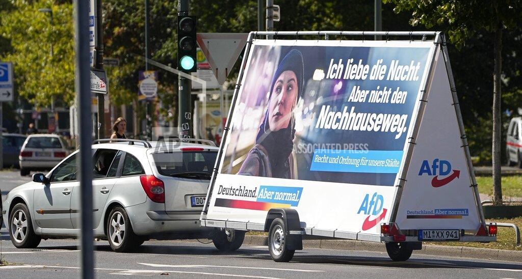 Martin Meissner FILE - In this Wednesday, Aug. 25, 2021 file photo a car pulls an election poster for the right wing party 'Alternative for Germany' (AfD) at a street in Duesseldorf, Germany. Migration is a side issue in this year's German election campaign, but that hasn't stopped the country's biggest far-right party from trying to play it up. (AP Photo/Martin Meissner)
