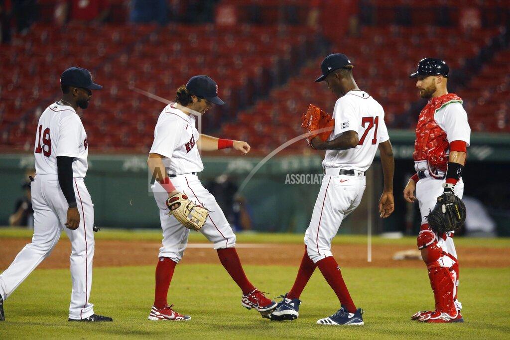 Michael Dwyer Boston Red Sox players, from left to right, Jackie Bradley Jr., Andrew Benintendi, Phillips Valdez and Jonathan Lucroy celebrate after defeating the Baltimore Orioles during an opening day baseball game at Fenway Park, Friday, July 24, 2020, in Boston. (AP Photo/Michael Dwyer)