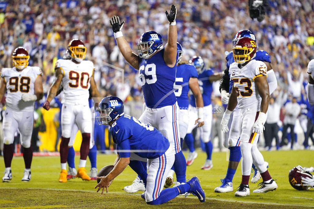 Patrick Semansky New York Giants quarterback Daniel Jones (8) gets up after after scoring a touchdown against the Washington Football Team during the first half of an NFL football game, Thursday, Sept. 16, 2021, in Landover, Md. Throwing his arms up is teammate New York Giants center Billy Price (69). (AP Photo/Patrick Semansky)