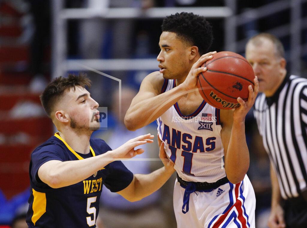 Colin E. Braley West Virginia guard Jordan McCabe (5) pressures Kansas guard Devon Dotson (11) during the second half of an NCAA college basketball game Saturday, Feb. 16, 2019, in Lawrence, Kan. (AP Photo/Colin E. Braley)