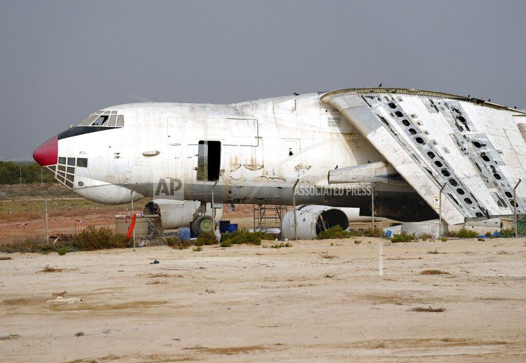 Kamran Jebreili An abandoned plane, Ilyushin Il-76, once tied to arms smuggler Viktor Bout, is being dismantled at the old airfield of Umm al-Quwain, United Arab Emirates, Friday, May 27, 2022. The hulking, Soviet-era cargo plane has sat for decades under the blazing sun in this least-populated corner of the United Arab Emirates, its four jet engines silent after years in the employ of a Russian gunrunner infamously known as the "Merchant of Death." (AP Photo/Kamran Jebreili)