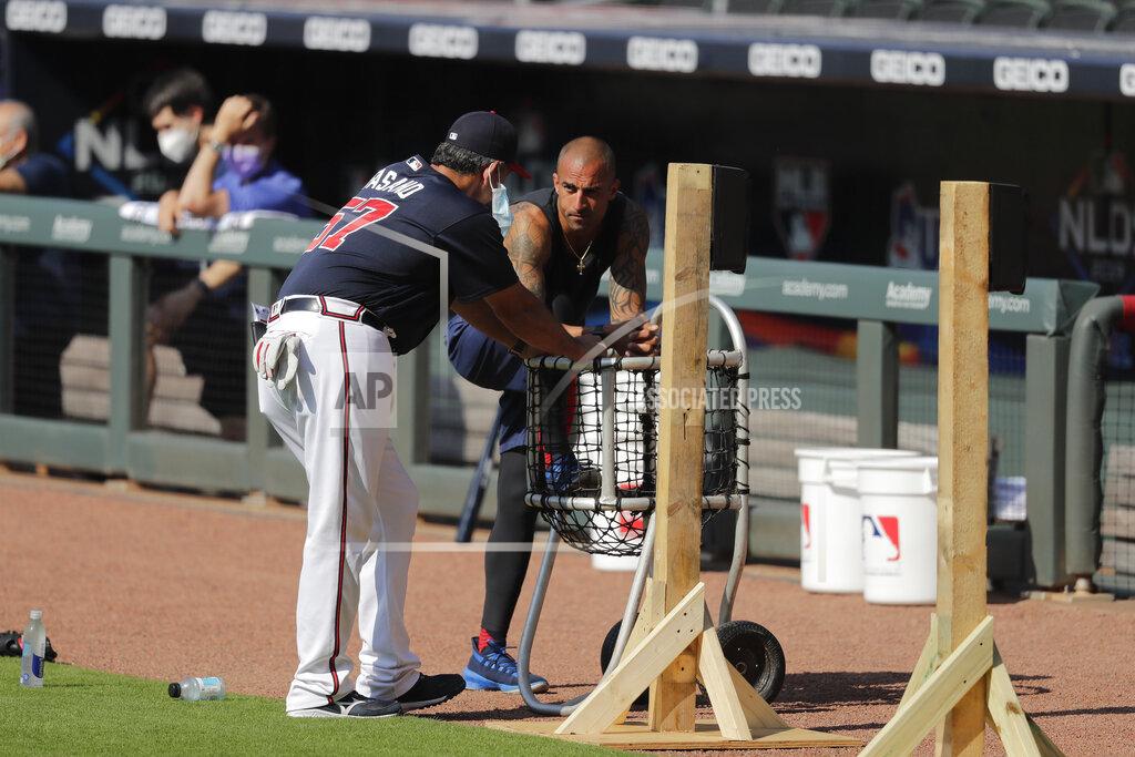 FILE - In this July 5, 2020, file photo, Atlanta Braves' Nick Markakis, right, talks with a coach during team practice at Truist Park in Atlanta. Braves outfielder Nick Markakis has opted out of the 2020 season. The 36-year-old Markakis said he was uneasy about playing the season without fans and then was swayed by his telephone conversation with teammate Freddie Freeman, who has tested positive for COVID-19 and has fever and other symptoms. (AP Photo/Brynn Anderson, File)