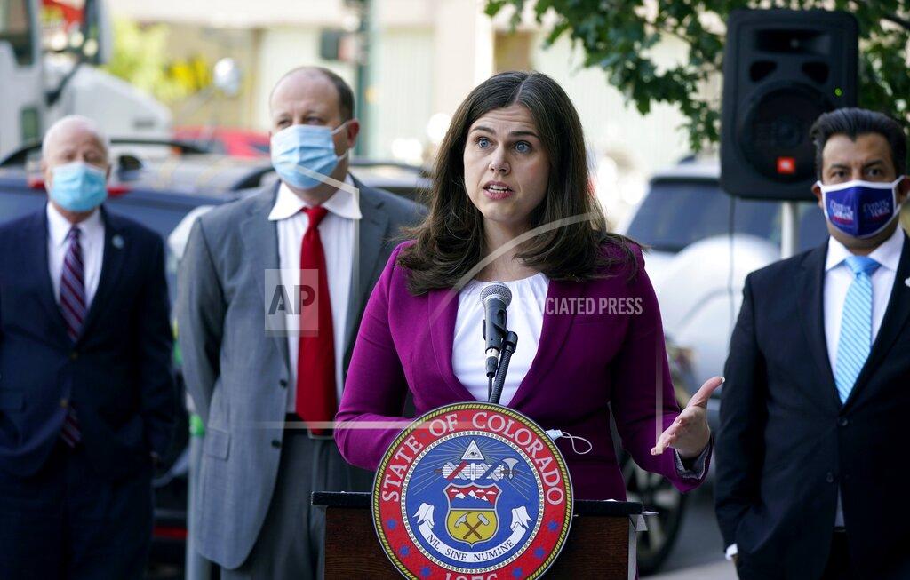 David Zalubowski FILE - In this Oct. 15, 2020, file photo, Colorado Secretary of State Jena Griswold, front, speaks as, from back left, Aurora, Colo., Mayor Mike Coffman, Colorado Gov. Jared Polis, and Denver Clerk and Recorder Paul Lopez look on during a news conference about the state's efforts to protect the process of casting a vote in the upcoming general election in downtown Denver. Colorado Gov. Jared Polis is quarantining himself after learning that Aurora Mayor Mike Coffman tested positive for the coronavirus. Coffman's diagnosis on Sunday, Oct. 25, 2020, came over a week after he and the governor appeared with other officials at a news conference. A Polis spokesperson said the governor would quarantine while waiting to hear from contact tracers. Coffman said he worked from home starting Thursday after not feeling well and his symptoms were gone by Saturday. He says he got a rapid test Sunday in hopes of being cleared to return to his office and schedule but will now quarantine at home. (AP Photo/David Zalubowski, File)
