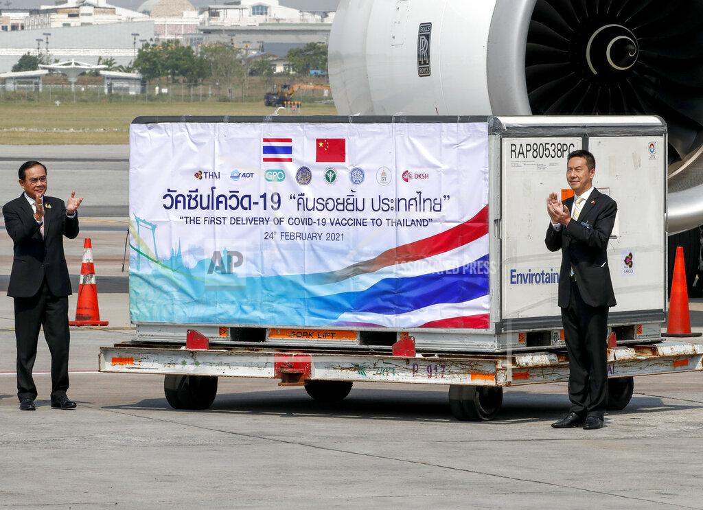Sakchai Lalit Prime Minister Prayuth Chan-ocha, left, and Yang Xin, right, Charge d'Affaires of China embassy of Thailand clap during a ceremony to mark the arrival of 200,000 doses of the Sinovac vaccine shipment at Suvarnabhumi airport in Bangkok, Thailand, Wednesday, Feb. 24, 2021. Thailand is scheduled to receive first shipments of 200,000 doses of the Sinovac vaccine and 117,000 doses of the AstraZeneca vaccine on Feb. 24. (AP Photo/Sakchai Lalit)