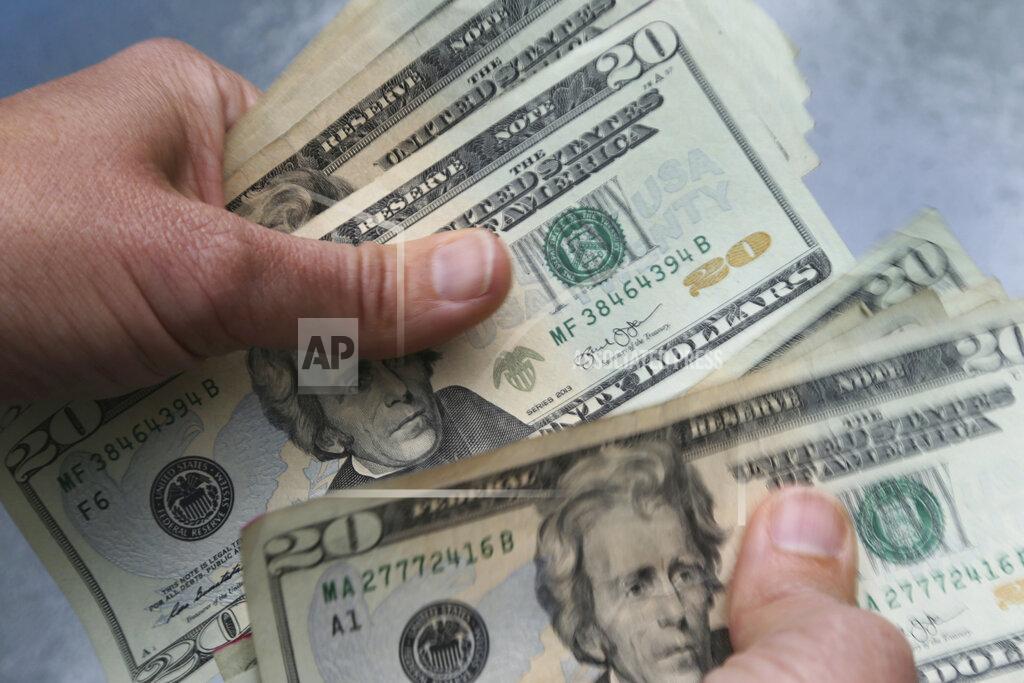 FILE - In this June 15, 2018 file photo, twenty dollar bills are counted in North Andover, Mass. Amid the pandemic-fueled recession, your job description and responsibilities may have changed. Whether you’ve taken on more tasks after employees were laid off or your household income has taken a hit, there are plenty of reasons to negotiate your salary even in tough times. (AP Photo/Elise Amendola, File)