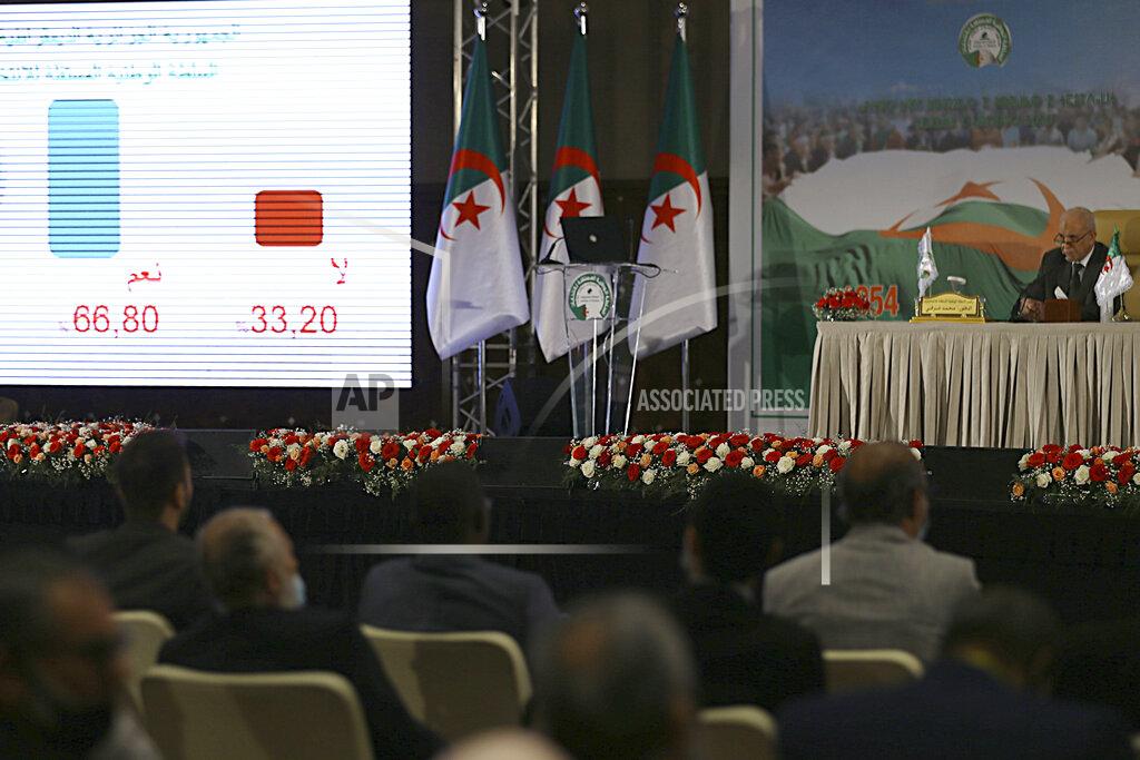 Anis Belghoul Mohamed Charfi, right, head of the Algerian Elections National Authority presents the results of the referendum in Algiers, Monday, Nov.2, 2020. Algerians have approved a revised constitution that imposes term limits and is aimed at answering demands from pro-democracy protesters who pushed out the president last year. (AP Photo/Anis Belghoul)