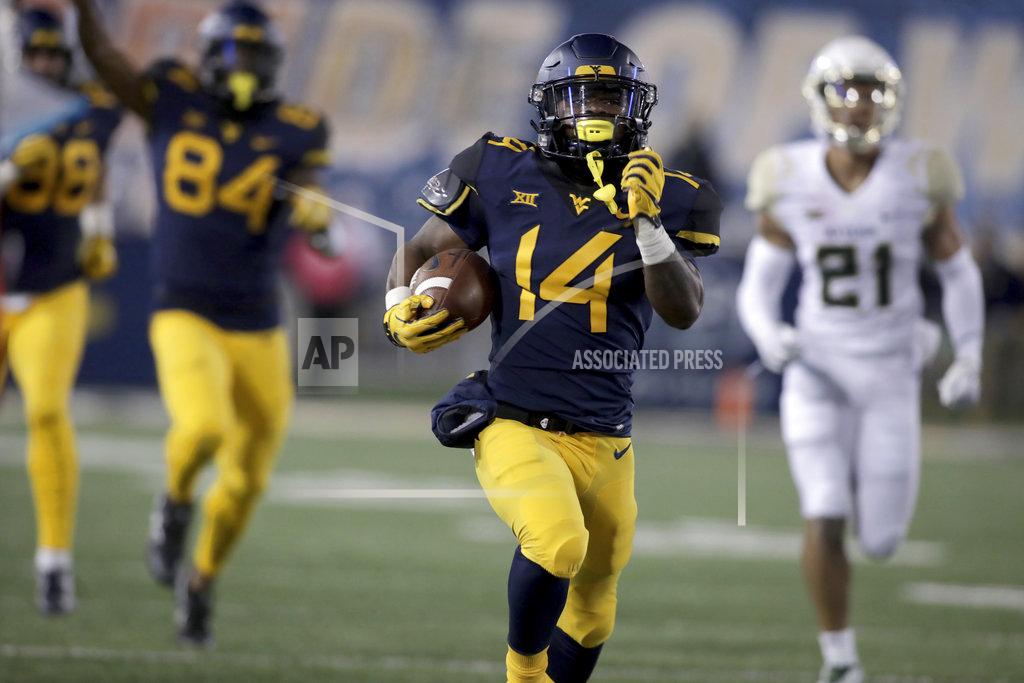 Ray Thompson West Virginia running back Tevin Bush (14) runs for a touchdown during the first half of an NCAA college football game against Baylor, Thursday, Oct. 25, 2018, in Morgantown, W.Va. (AP Photo/Raymond Thompson)