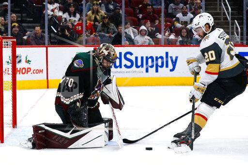 Arizona Coyotes goaltender Karel Vejmelka (70) makes a save on Vegas Golden Knights center Chandler Stephenson (20) during the second period of an NHL hockey game Friday, Dec. 3, 2021, in Glendale, Ariz. (AP Photo/Ross D. Franklin)