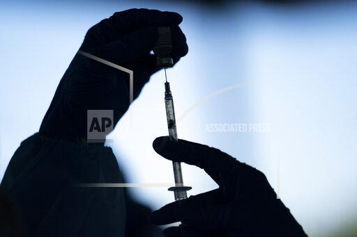 FILE - A medical staff member prepares the Pfizer-BioNTech COVID-19 vaccine at Tudor Ranch in Mecca, Calif. on Jan. 21, 2021. Merriam-Webster has declared vaccine its 2021 word of the year. (AP Photo/Jae C. Hong, File)