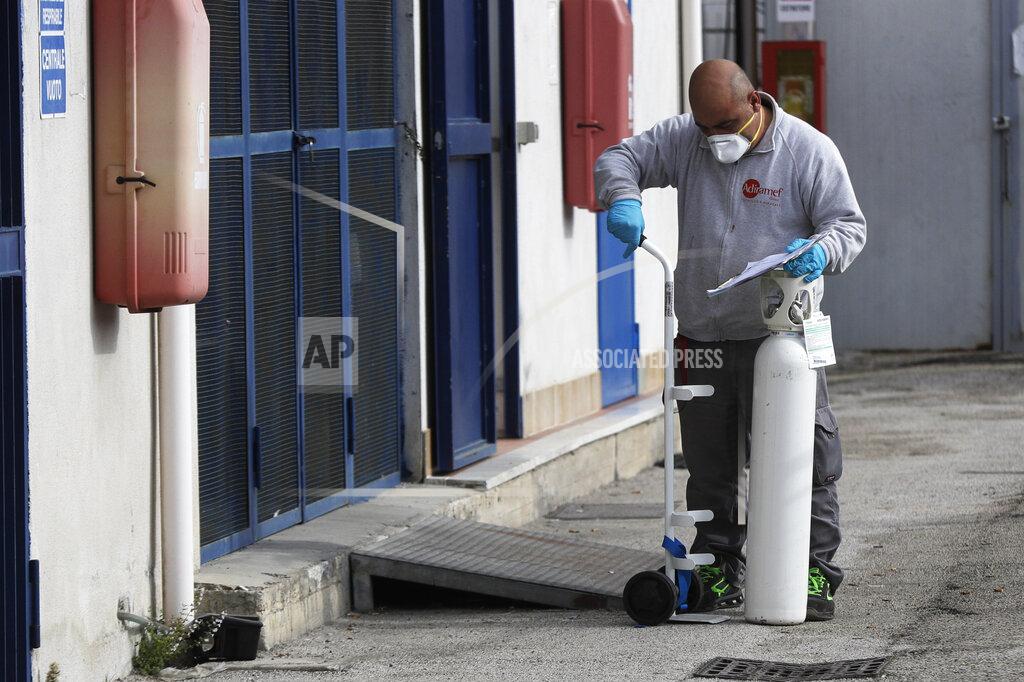 Gregorio Borgia A man loads an oxygen canister near the first aid department of the San Giuliano hospital in Giugliano in the outskirts of Naples, Italy, Saturday, Nov. 14, 2020. The pandemic has heightened the urgency of the plight of those seeking medical care in public hospitals in Italy’s economically under-developed south. (AP Photo/Gregorio Borgia)