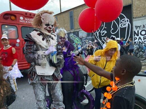 A costumed man greets a young boy at the Krewe of Boo parade on Saturday, Oct. 23, 2021, in New Orleans. (AP Photo/Rebecca Santana)