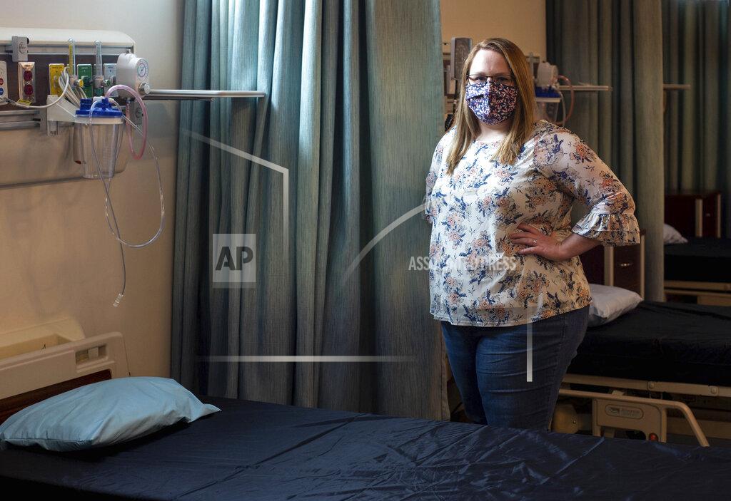 Daniel Lin In this May 11, 2021 photo, Heather Fitzgerald, a recent Blue Ridge Community College nursing graduate, poses for a photo in a nursing lab in Weyers Cave, Va. (Daniel Lin/Daily News-Record via AP)