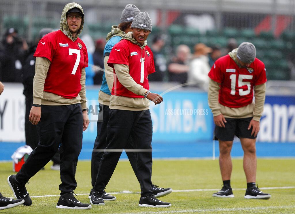 Frank Augstein Jaguars quarterbacks Joshua Dobbs, centre, Nick Foles, left, and Gardner Minshew II warm up during a NFL training session of the Jacksonville Jaguars at the at Allianz Park in London, Friday, Nov. 1, 2019.The Jacksonville Jaguars are preparing for an NFL regular season game against the Houston Texans in London on Sunday. (AP Photo/Frank Augstein)