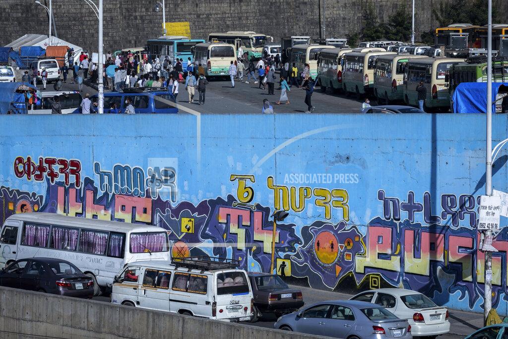 Mulugeta Ayene Passengers look for buses at a station, while vehicle drivers sit in traffic nearby, in the capital Addis Ababa, Ethiopia Friday, Nov. 6, 2020. Ethiopia's prime minister says airstrikes have been carried out against the forces of the country's Tigray region, asserting that the strikes in multiple locations "completely destroyed rockets and other heavy weapons." Coronavirus informational mural in Amharic reads "Keep your distance, everything will be alright soon". (AP Photo/Mulugeta Ayene)