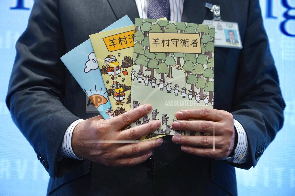 Vincent Yu Li Kwai-wah, senior superintendent of Police National Security Department, poses with evidence including three children's books on stories that revolve around a village of sheep which has to deal with wolves from a different village, before a press conference in Hong Kong Thursday, July 22, 2021. Hong Kong's national security police on Thursday arrested five people from a trade union of the General Association of Hong Kong Speech Therapists on suspicion of conspiring to publish and distribute seditious material, in the latest arrests made amid a crackdown on dissent in the city.(AP Photo/Vincent Yu)