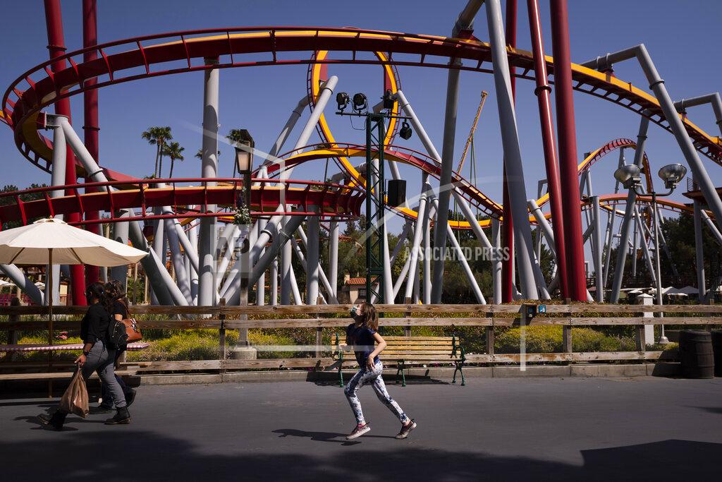 Jae C. Hong A young visitor runs past a ride to catch up with her family during the Knott's Taste of Boysenberry Festival at Knott's Berry Farm in Buena Park, Calif., Tuesday, March 30, 2021. Massive Los Angeles County can reopen even more businesses, California public health officials announced Tuesday. The county of 10 million people was one of several counties, including neighboring Orange County, that moved into the state's second-least restrictive orange tier amid low coronavirus case rates. (AP Photo/Jae C. Hong)