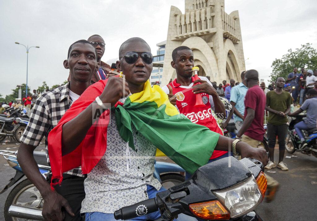 Uncredited A man wears a national flag as he celebrates with others in the streets in the capital Bamako, Mali Tuesday, Aug. 18, 2020. Mutinous soldiers detained Mali's president and prime minister Tuesday after surrounding a residence and firing into the air in an apparent coup attempt after several months of demonstrations calling for President Ibrahim Boubacar Keita's ouster. (AP Photo)