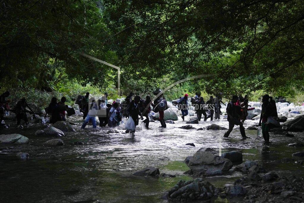 Fernando Vergara Migrants cross the Acandi River as they continue on their trek north, in Acandi, Colombia, Wednesday, Sept. 15, 2021. The migrants, following a well-beaten, multi-nation journey towards the U.S., will continue their journey through the jungle known as the Darien Gap. (AP Photo/Fernando Vergara)