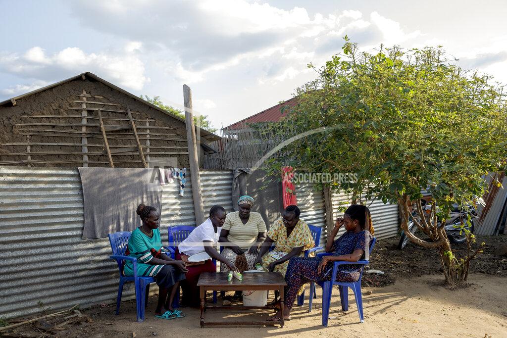 Adrienne Surprenant Paska Itwari Beda, right, meets with neighbours at her Juba, South Sudan home, Saturday, May 29, 2021. They gather weekly, pooling supplies and handing them out to a different family every week. Over coffee, they share advice. They are from different ethnic groups - a counterpoint to the tensions of the civil war - and say the group is a reflection of their shared trust. (AP Photo/Adrienne Surprenant)