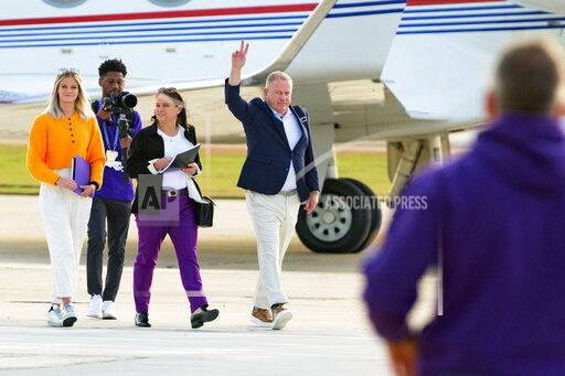 New LSU football coach Brian Kelly gestures to fans after his arrival at Baton Rouge Metropolitan Airport, Tuesday, Nov. 30, 2021, in Baton Rouge, La. Kelly, formerly of Notre Dame, is said to have agreed to a 10-year contract with LSU worth $95 million plus incentives. (AP Photo/Matthew Hinton)