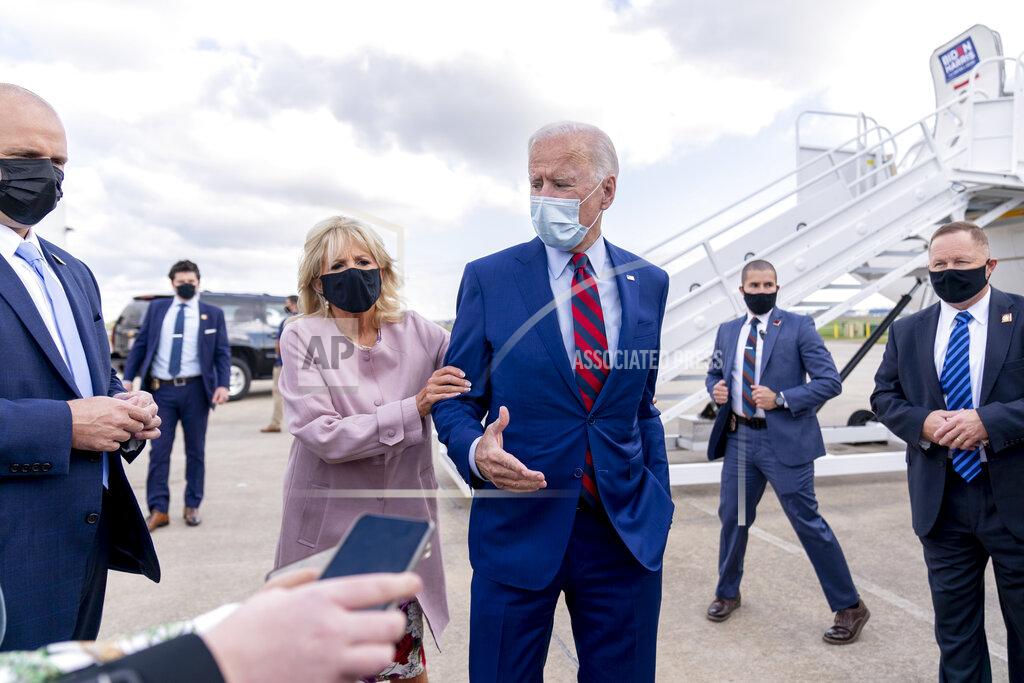 FILE - In this Oct. 5, 2020 file photo, Jill Biden moves her husband, Democratic presidential candidate former Vice President Joe Biden, back from members of the media as he speaks outside his campaign plane at New Castle Airport in New Castle, Del., to travel to Miami for campaign events. Protecting Joe stands out among Jill Biden's many roles over their 43-year marriage, as her husband's career moved him from the Senate to the presidential campaign trail and the White House as President Barack Obama's vice president. She's a wife, mother, grandmother and educator with a doctoral degree — as well as a noted prankster who will soon be putting her own stamp on what it means to be first lady. (AP Photo/Andrew Harnik, File)