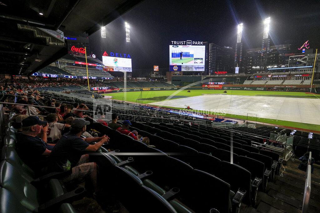 Butch Dill Fans wait for play to resume during a weather delay in the fifth inning of a baseball game between the Atlanta Braves and the St. Louis Cardinals, Monday, July 4, 2022, in Atlanta. (AP Photo/Butch Dill)
