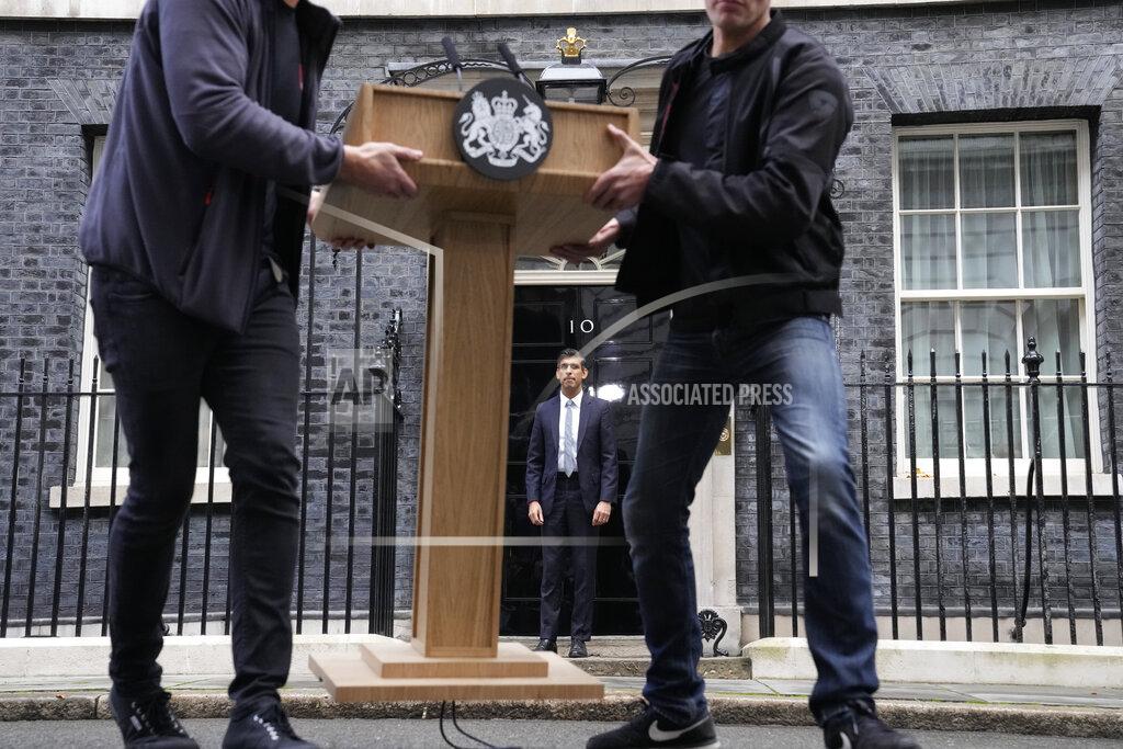 Frank Augstein FILE - New British Prime Minister Rishi Sunak, centre, poses for the media as the pulpit is moved after his speech at Downing Street in London, Tuesday, Oct. 25, 2022, after returning from Buckingham Palace where he was formally appointed to the post by Britain's King Charles III. In his first month as Britain's prime minister, Rishi Sunak has stabilized the economy, reassured allies from Washington to Kyiv and even soothed the European Union after years of sparring between Britain and the bloc. But Sunak’s challenges are just beginning. He is facing a stagnating economy, a cost-of-living crisis – and a Conservative Party that is fractious and increasingly unpopular after 12 years in power. (AP Photo/Frank Augstein, File)