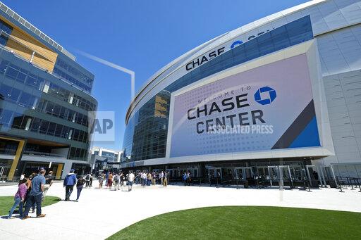 FILE - In this Aug. 26, 2019, file photo, people walk outside the Chase Center in San Francisco. Officials with the indoor arena home to the Golden State Warriors are assuring fans that Chase Center is safe as police investigate two separate falls at a Sunday night, Oct. 17, 2021, Phish concert, one of which resulted in death. Police said the concert-goer who fell to his death from the upper level of the arena is believed to have “leapt from an elevated area of the arena," causing his death. (AP Photo/Eric Risberg, File)