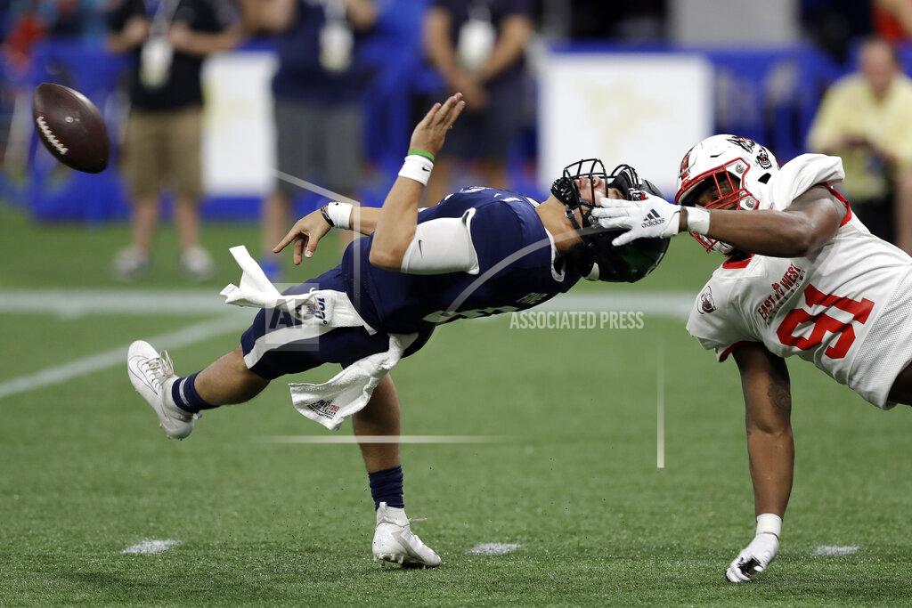 Chris O'meara West quarterback Mason Fine, of North Texas, (6) loses the football after getting hit by East defensive end James Smith-Williams, of North Carolina State, (91) during the second half of the East West Shrine football game Saturday, Jan. 18, 2020, in St. Petersburg, Fla. Smith-Williams was called for a facemask penalty. (AP Photo/Chris O'Meara)