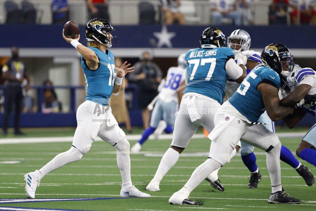 Jacksonville Jaguars quarterback Trevor Lawrence (16) throws a pass under protection from Jacksonville Jaguars' Tre'Vour Wallace-Simms (77) and Jawaan Taylor, right, in the first half of a preseason NFL football game against the Dallas Cowboys in Arlington, Texas, Sunday, Aug. 29, 2021. (AP Photo/Ron Jenkins)