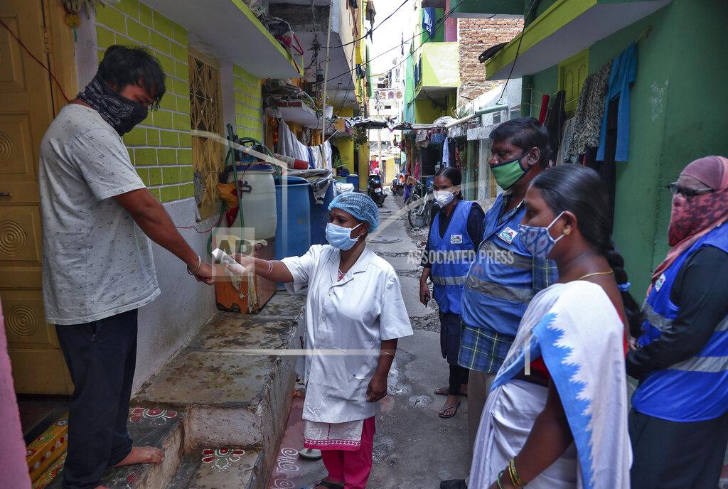 Mahesh Kumar A FILE - In this May 6, 2021, file photo, an Indian health worker checks body temperature of a man during a door-to-door survey being conducted as a precaution against COVID-19 in Hyderabad, India. The World Health Organization said Monday, May 10, that a worrisome variant was first detected in India may spread more easily. Scientists are still trying to figure out if it resulted in the terrifying surge of infections in the nation, and looking to see if this could this happen elsewhere. (AP Photo/Mahesh Kumar A., File)