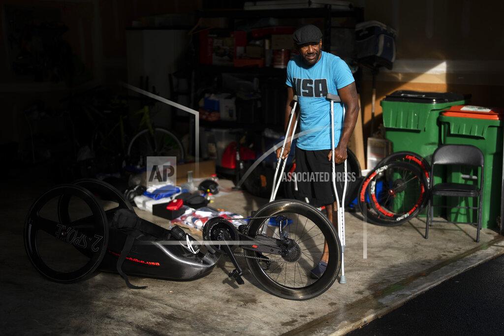 Emilio Morenatti Freddie De Los Santos stands next to his bicycle before his daily training in Hopewell Junction, N.Y., on Wednesday, Aug. 19, 2021. His life changed in 2009, when a rocket-propelled grenade ripped into his vehicle in an Afghan village. He remembers his beard burning, and grabbing his leg after it was ripped off by the blast. (AP Photo/Emilio Morenatti)