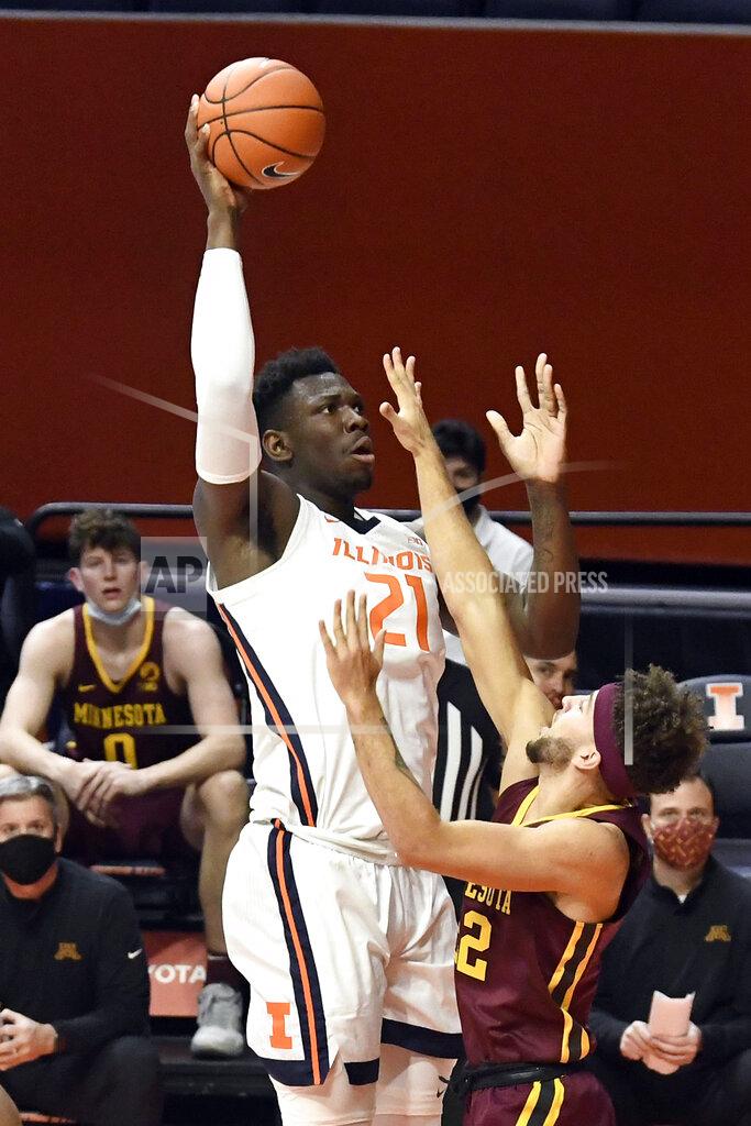 Holly Hart Illinois center Kofi Cockburn (21) puts the ball up as Minnesota's guard Gabe Kalscheur (22) defends in the first half of an NCAA college basketball game Tuesday, Dec. 15, 2020, in Champaign, Ill. (AP Photo/Holly Hart)