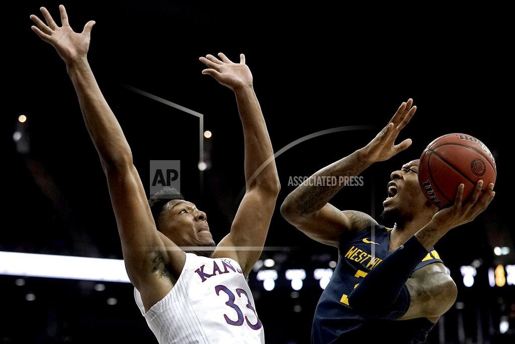 Charlie Riedel West Virginia forward Gabe Osabuohien, right, shoots under pressure from Kansas forward David McCormack (33) during the first half of an NCAA college basketball game in the quarterfinal round of the Big 12 Conference tournament in Kansas City, Mo., Thursday, March 10, 2022. (AP Photo/Charlie Riedel)