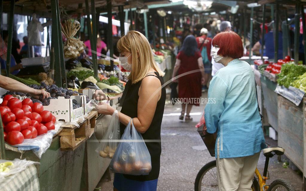 Boris Grdanoski Women shop at a market in Skopje, North Macedonia on Thursday, July 16, 2020. The pro-Western SDSM party in North Macedonia is poised to try to form a coalition government following a narrow election victory. (AP Photo/Boris Grdanoski)