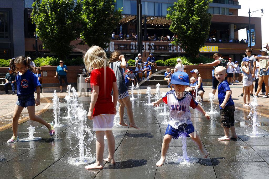 Shafkat Anowar Kids play around a water fountain outside of Chicago's Wrigley Field before a baseball game, Friday, June 11, 2021, as Chicago and rest of Illinois fully reopens ending an over a year-long COVID-19 restrictions. (AP Photo/Shafkat Anowar)