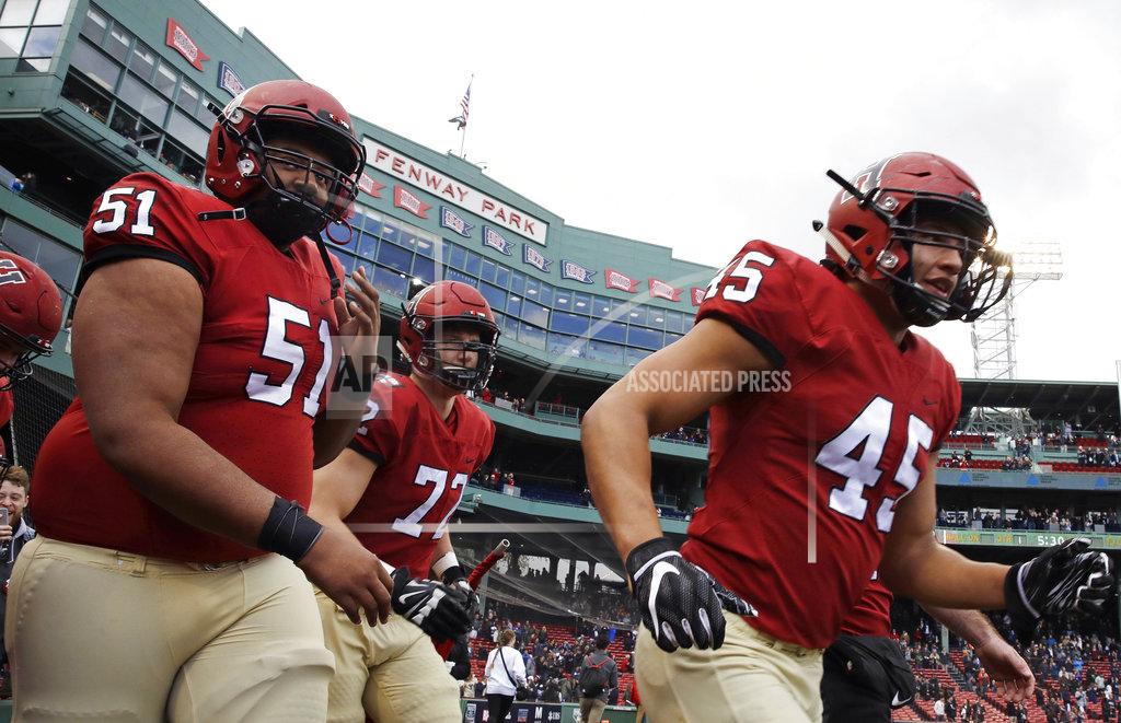 Charles Krupa Harvard offensive lineman Justin Hunter (51) and linebacker Jake Brown (45) take to the field prior to the opening kick-off during an NCAA college football game at Fenway Park in Boston, Saturday, Nov. 17, 2018. (AP Photo/Charles Krupa)