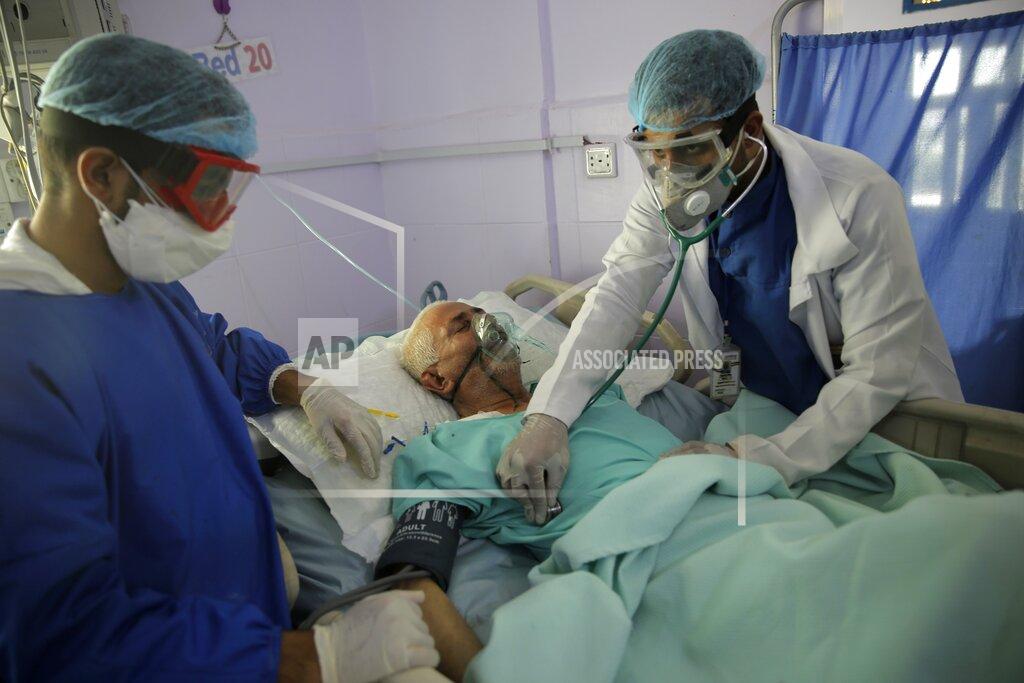 Hani Mohammed FILE - In this Sunday, June 14, 2020 file photo, medical workers attend to a COVID-19 patient in an intensive care unit at a hospital in Sanaa, Yemen. For months, experts have warned of a potential nightmare scenario: After overwhelming health systems in some of the world's wealthiest regions, the coronavirus gains a foothold in poor or war-torn countries ill-equipped to contain it and sweeps through the population. (AP Photo/Hani Mohammed, File)