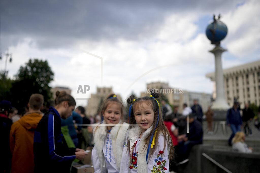 Natacha Pisarenko Girls smile at downtown Kyiv, Ukraine, Monday, May 23, 2022. No matter where they live, the 3-month-old war never seems to be far away for Ukrainians. Those in towns and villages near the front lines hide in basements from constant shelling, struggling to survive with no electricity or gas — and often no running water. But even in regions out of the range of the heavy guns, frequent air raid sirens wail as a constant reminder that a Russian missile can strike at any time — even for those walking their dogs, riding their bicycles and taking their children to parks in cities like Kyiv, Kharkiv, Odesa and Lviv.(AP Photo/Natacha Pisarenko)
