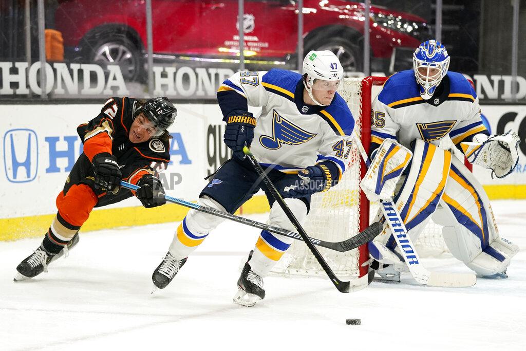 Mark J. Terrill St. Louis Blues defenseman Torey Krug, center, skates with the puck as Anaheim Ducks left wing Sonny Milano, left, reaches in and goaltender Ville Husso watches during the second period of an NHL hockey game Monday, March 1, 2021, in Anaheim, Calif. (AP Photo/Mark J. Terrill)