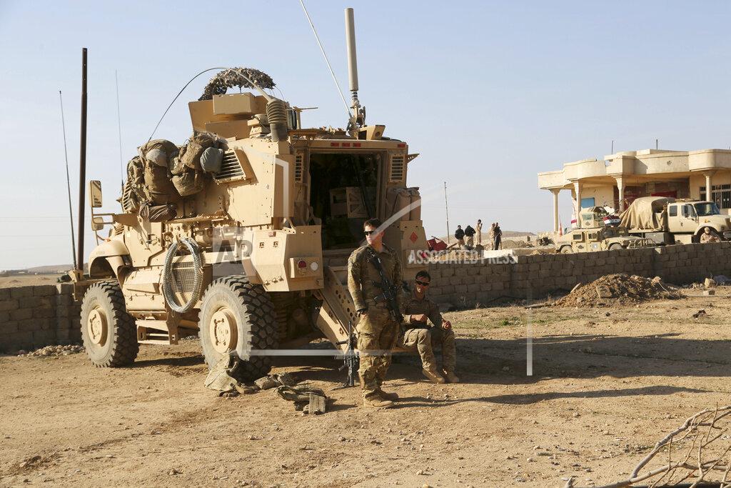 Khalid Mohammed FILE - In this Feb. 23, 2017 file photo, U.S. Army soldiers stand outside their armored vehicle on a joint base with the Iraqi army, south of Mosul, Iraq. In a quest to root out Islamic State group hideouts over the summer, Iraqi forces on the ground cleared nearly 90 villages across a notoriously unruly northern province. But the much-touted operation still relied heavily on U.S. intelligence, coalition flights and planning assistance. (AP Photo/ Khalid Mohammed, File)