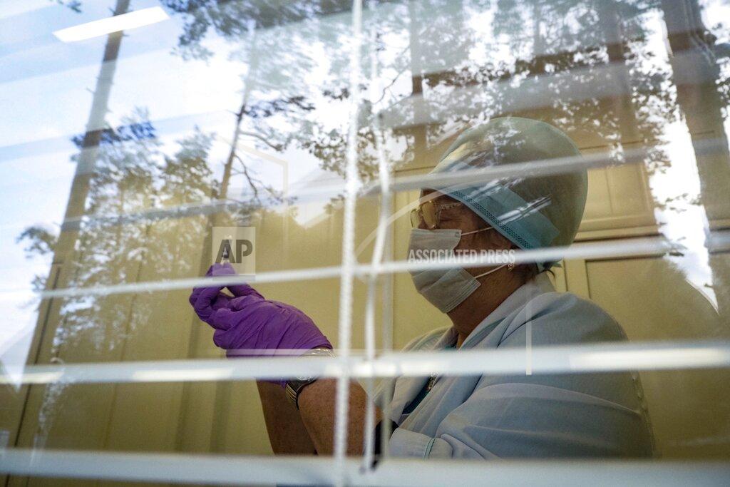 Dmitri Lovetsky A medical worker preparing a shot of Russia's Sputnik V coronavirus vaccine is seen through a window of a local rural medical post in the village of Ikhala in Russia’s Karelia region, Tuesday, Feb. 16, 2021. Russia took pride in being the first country to approve a coronavirus vaccine, although it faced criticism from aboard for doing it before completing the advanced testing necessary to ensure Sputnik V’s safety and effectiveness. (AP Photo/Dmitri Lovetsky)